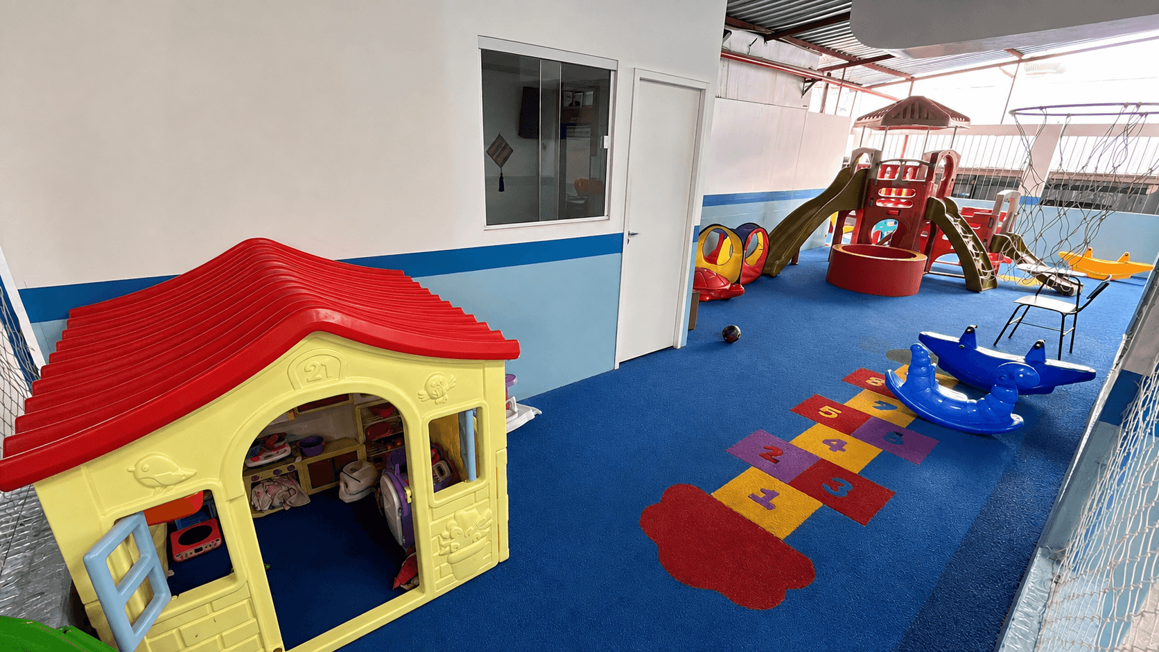 Playground infantil coberto e seguro com brinquedos e amarelinha no Colégio Maha Dei